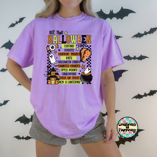 Person wearing a purple t-shirt with Halloween-themed graphics and text, standing against a background with bats.
