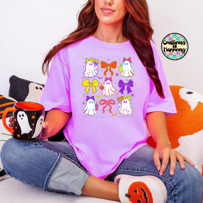 Person wearing a purple t-shirt with colorful designs, holding a mug, sitting on a couch.
