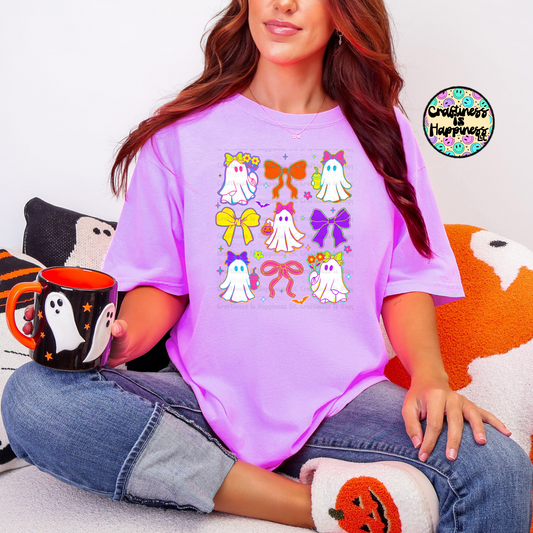 Person wearing a purple t-shirt with colorful designs, holding a mug, sitting on a couch.