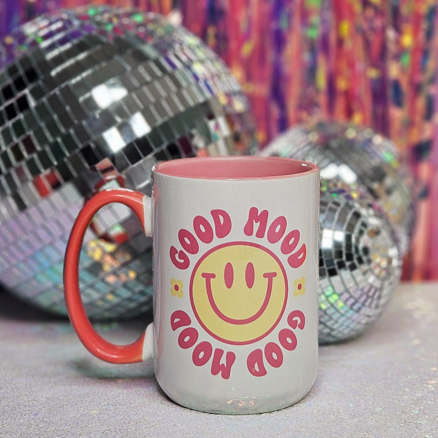 white 15oz mug "Good Mood" in pink text, yellow smiley face with pink trim, and yellow daisies, pink inside trim and pink handle 