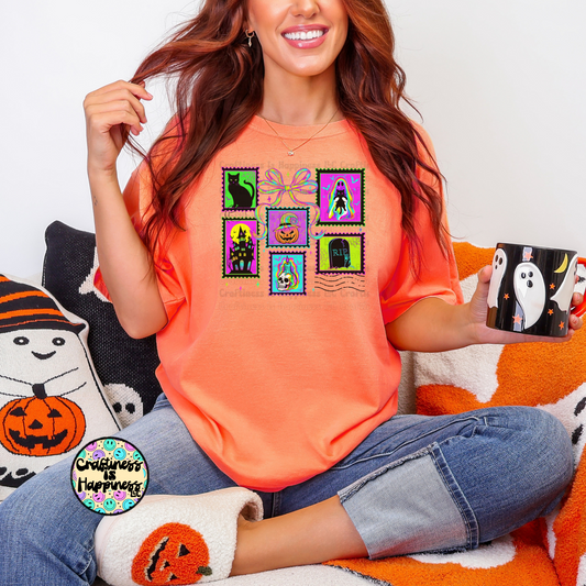 Woman wearing an orange t-shirt with Halloween-themed designs, sitting on a couch with Halloween decorations.