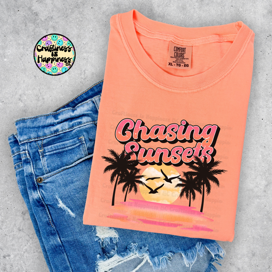 Neon Cantaloupe T-Shirt with 'Chasing Sunsets' design on a concrete surface with jeans.