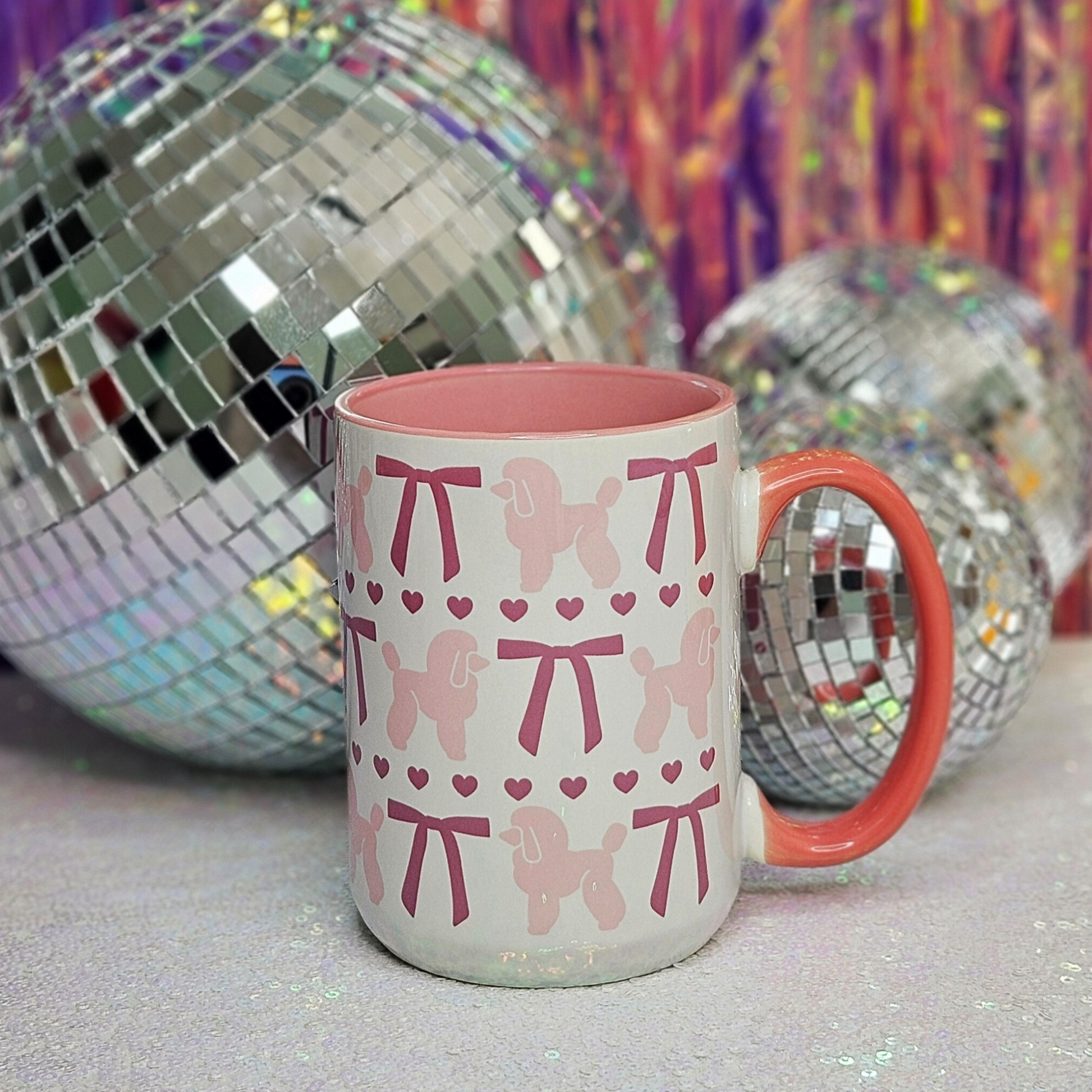 white mug with pink inside trim and pink handle, light pink poodles, pink bows, and pink hearts