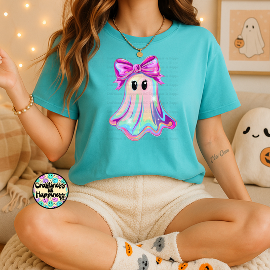 Person wearing a turquoise t-shirt with a colorful octopus design, sitting on a couch.