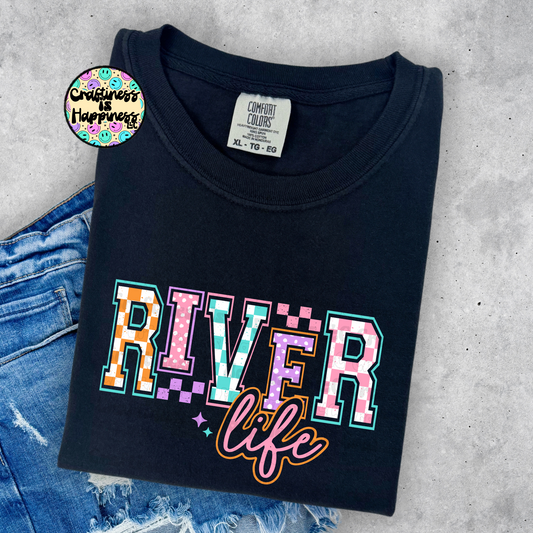 Black t-shirt with 'River life' design on a concrete surface