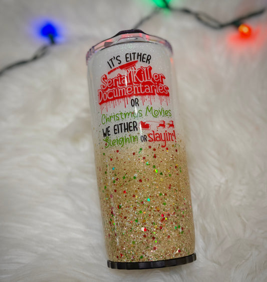 Glittery tumbler with Christmas-themed text on a white background with string lights.