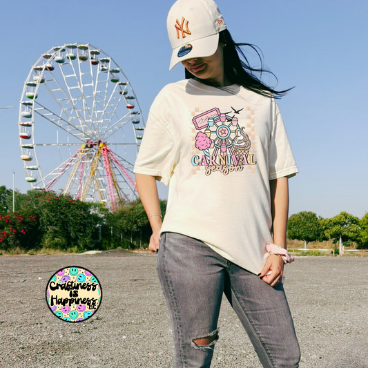 Person wearing a 'Carnival' t-shirt with a Ferris wheel in the background
