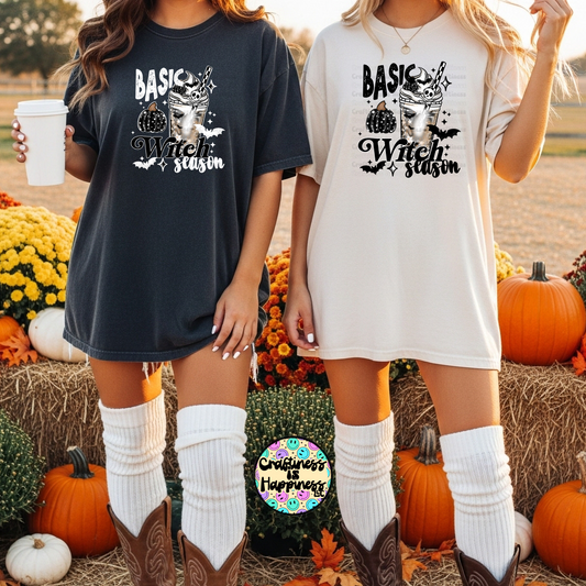 Two women wearing 'Basic Witch Season' t-shirts in a pumpkin patch setting.
